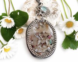 Handgefertigter ovaler Silberanhänger mit Chrysokoll Chalcedon und Muschel Charm, umrahmt von weißen Gänseblümchen.