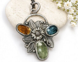 Handgearbeiteter Sonnenblumen-Kettenanhänger aus Echtsilber mit transparenten Kyaniten.